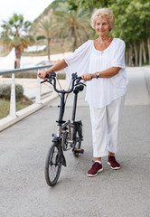 Obraz premium Elderly woman going to biking