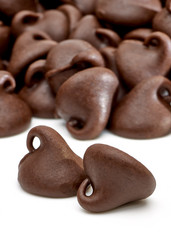 Chocolate drops or chocolate chips morsels close up view isolated on white background