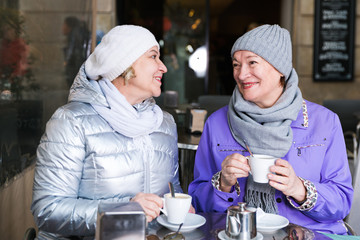 Fototapeta na wymiar Smiling elderly females at outdoor cafe