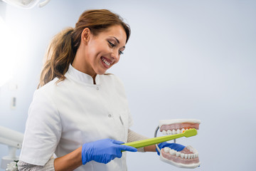 Girl at the dentist learning how to brush her teeth