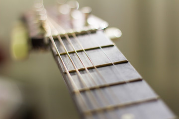 the neck of the old guitar with missing strings,shallow depth of field