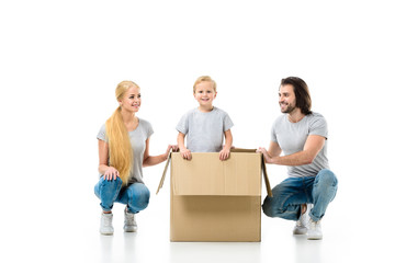 Happy family with little son in a big moving paper box isolated on white