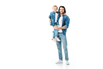 Fototapeta premium Father holding his pretty son and looking at camera isolated on white