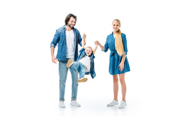 Fototapeta premium Lovely parents throwing up their child while holding hands isolated on white