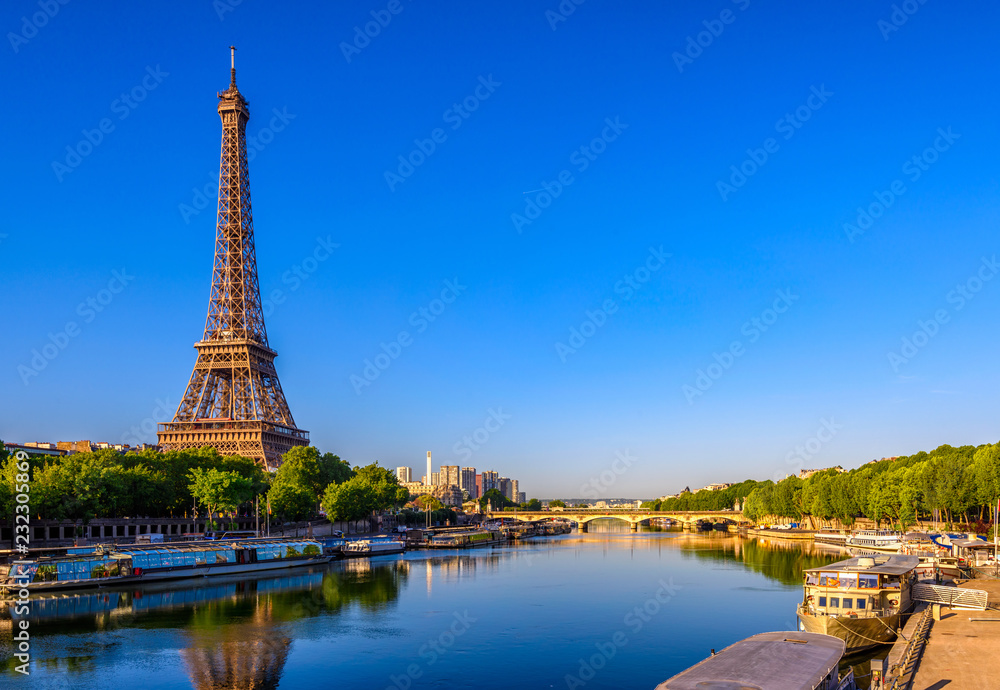 Wall mural view of eiffel tower and river seine at sunrise in paris, france. eiffel tower is one of the most ic