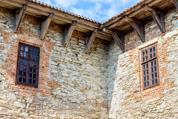 Part of the wall of ancient building with wooden windows_