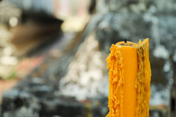 Closeup of a yellow candle and candle tears with natural background. 