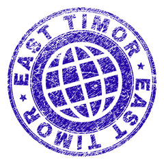 EAST TIMOR stamp print with distress effect. Blue vector rubber seal print of EAST TIMOR title with dirty texture. Seal has words arranged by circle and planet symbol.