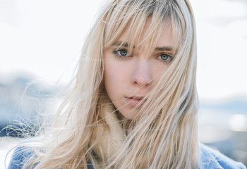 Portrait of young woman wearing blue coat.