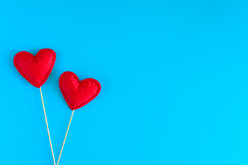 Fototapeta na wymiar Felt love hearts on booth props on blue paper background. Valentine's day celebration concept. Top view. Flat lay