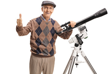 Senior man with a telescope looking at the camera and giving thumb up