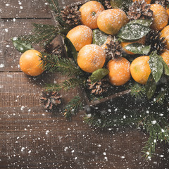 Fresh mandarins with leaves on wooden board. Christmas composition with copy space.