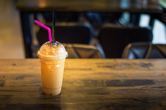 Coffee or cocoa freppe on the wooden table with the blurred background in the coffee shop