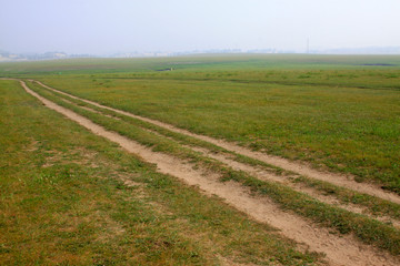 Fototapeta na wymiar unsurfaced road in the WuLanBuTong grassland, China
