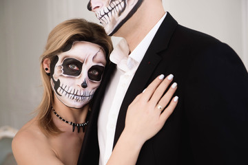 A couple with skeleton make up for Halloween or All Souls Day