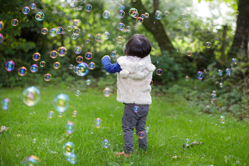 toddle baby girl play bubble at Spring garden