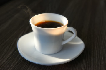 Black hot coffee with sunlight on table