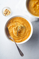 Pureed pumpkin soup with seeds and thyme. Warm food concept, dieting. Concrete background, overhead view.