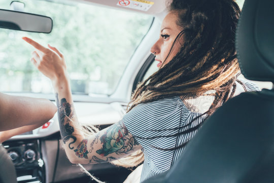 Woman giving direction to driver inside vehicle