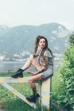 Woman sitting on wooden gate