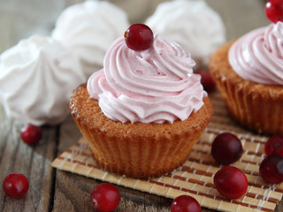 Cream muffins decorated with berries and marshmallows.