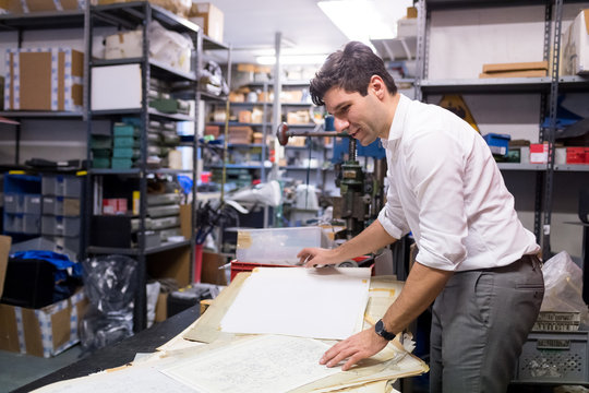 Man working on charts and plans in warehouse