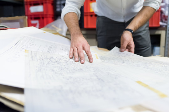 Man working on charts and plans in warehouse