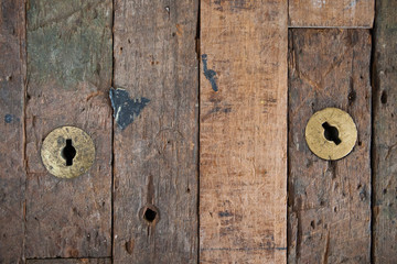 Close up of an old wooden door with brass fittings showiong