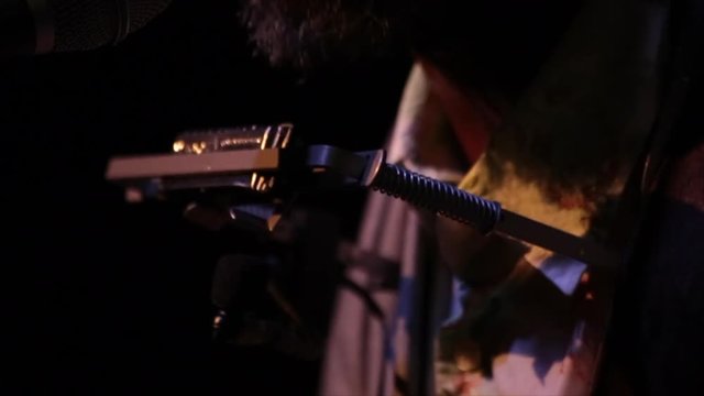 Close up of singer wearing harmonica holder as he sings