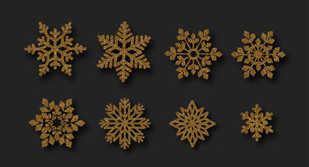 Set of beautiful shiny golden snowflakes isolated on black background.