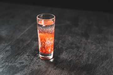 Bartender pours alcoholic drink into small glasses on bar. Colorful cocktails at the bar. Colorful...