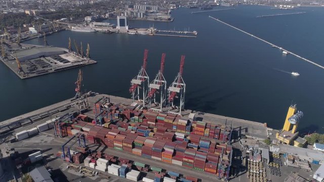 ODESSA, UKRAINE - OCTOBER 17, 2018: drone view of trading port industry with containers and lifting cranes for loading and unloading of vessel on Black Sea quayside