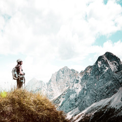 Woman standing on grass mountain summit