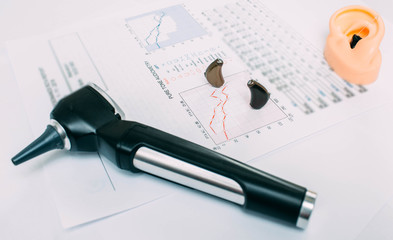 Hearing exam result - audiogram and hearing aids on the table