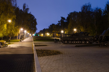 Autumn park with glowing lanterns. Tank and near baby stroller.
