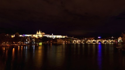 Fototapeta premium A panoramic view Prague Castle, the Charles Bridge and the Vltava River in the beautiful city of Prague, Czech Republic - Europe. A beautiful night photo of the architecture of the capital.