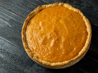 Close - up of pumpkin pie on wooden dark table