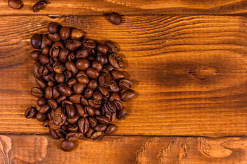 Pile of the coffee beans on wooden table. Top view