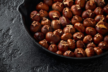 Roasted chestnuts served in cast iron vintage pan.