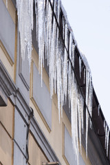 zwisające sople lodowe z dachu budynku