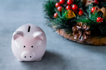 Pink pig and a Christmas wreath on a gray background. Concept of Christmas and New Year. Eastern New Year.