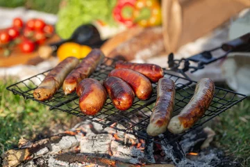 Foto op Plexiglas пикник с колбасками гриль на решетке и свежими овощами © lenakorzh