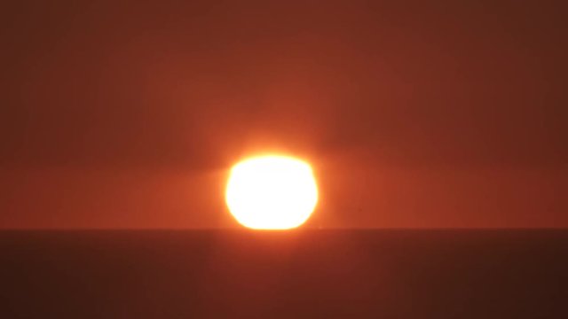 Time lapse of sunset day to night over ocean horizon on warm and clear sky.
