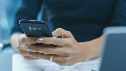 Shot of the Married Businesswoman Working at Her Office Desk Using Her Smartphone. Focus on a Phone.