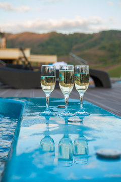 Three glass of cool champagne wine outdoor in a restaurant pool, terrace in mountain