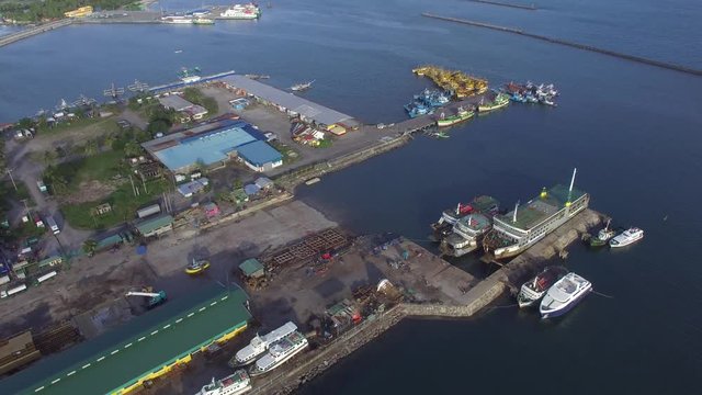 Dalahican, Lucena City, Philippines - December 28, 2017: View of fishing port and dock yard where boats are anchored side by side. Drone Aerial