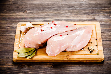 Raw chicken breasts on cutting board