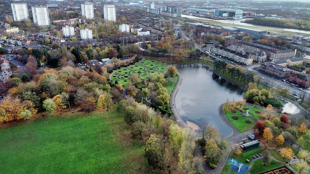 Aerial image over the pond in Victoria Park in Glasgow on bright autumn day. 