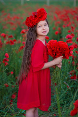 Naklejka premium Amazing close up portrait of lovely cute young romantic girl with poppy flower in hand posing on field background. Wearing red stylish vamp dress or bouquet of flowers. Soft colors. Girl power