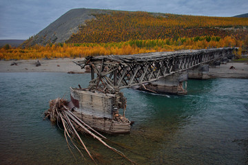 Russia. far East. Magadan region. Wooden bridge destroyed by ruthless time